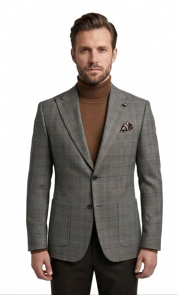 A man modeling a grey plaid suit jacket over a brown turtleneck sweater, paired with dark trousers and brown dress shoes, on a solid white background.
