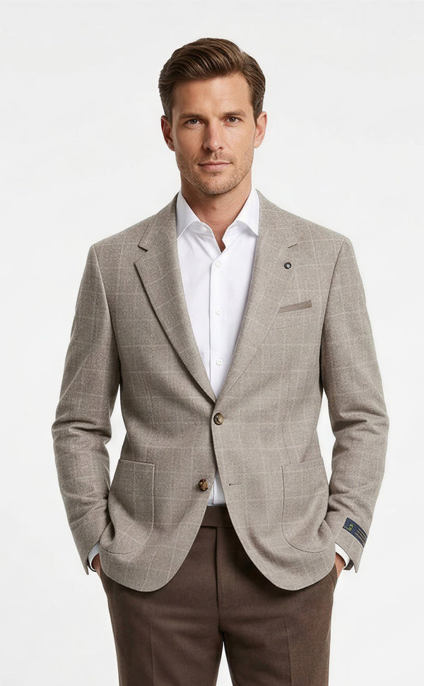 A man modeling a light beige textured blazer with brown trousers, a white dress shirt, and brown leather shoes, standing against a plain white studio background.